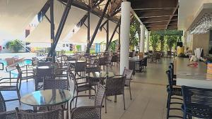 an empty dining room with tables and chairs at Sun Bay Pipa Hotéis in Pipa