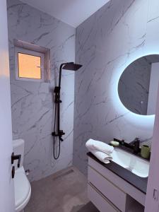 a white bathroom with a shower and a sink at Villa Çela in Lukovë