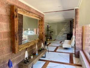a living room with a mirror on a brick wall at Casa Lago Colbun in Talca