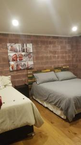 a bedroom with two beds and a brick wall at Casa Lago Colbun in Talca +20 photos