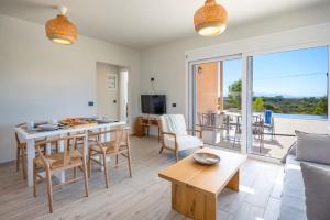 a living room with a table and a kitchen with a view at MENTOROS VILLAS in Karavádhos
