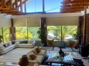 a large living room with couches and a large window at Casa Lago Colbun in Talca