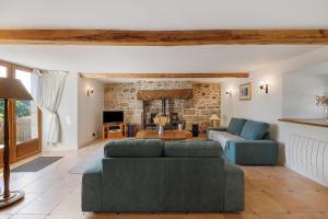 a living room with two couches and a fireplace at Longère Colpernou in Plouguernével