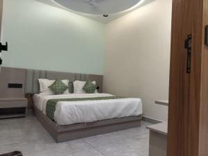 a bedroom with a large bed with pillows on it at Hotel Raddizone in Gandhinagar +15 photos