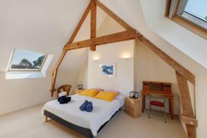 a bedroom with a bed and a desk in a attic at Longère Colpernou in Plouguernével +28 photos
