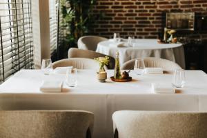 a row of tables in a restaurant with white tables and chairs at Hotel Tholen in Tholen