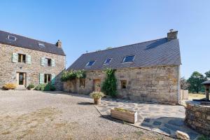 an old stone house with a courtyard in front of it at Longère Colpernou in Plouguernével