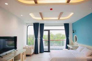 a bedroom with a bed and a large window at Aviera Boutique in Liên Trì (4) +40 photos