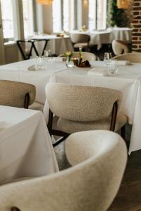 a restaurant with tables and chairs with white tablecloths at Hotel Tholen in Tholen