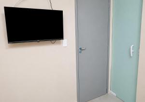 a flat screen tv hanging on a wall at Hotel Campina Center in Campina Grande