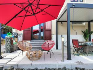 a group of chairs and red umbrellas in front of a house at Studio très calme 5mn VICHY in Bellerive-sur-Allier