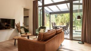 a living room with a couch and a table at Dutchen Zeegser Duinen Suitelodges in Zeegse