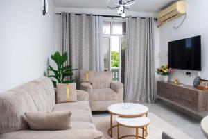 a living room with a couch and a tv at Vista del mar homes in Malindi