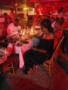 a group of people sitting around a table with candles at Torchys in Kisumu