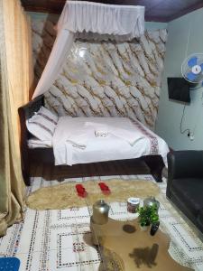 a living room with a bed and a table at Torchys in Kisumu