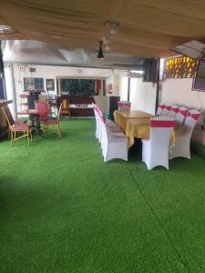 a dining room with green flooring and a table and chairs at Torchys in Kisumu +25 photos