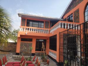 an orange house with chairs in front of it at Torchys in Kisumu