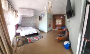 a bedroom with a bed and a table in it at Torchys in Kisumu