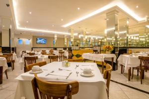 a dining room with white tables and chairs at Argentina Hotel in Rio de Janeiro