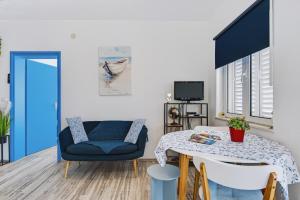 a living room with a blue chair and a table at Apartments Joy in Cavtat