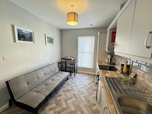 a living room with a couch and a kitchen at Ogle Street 1-Bed Apartment in Armagh