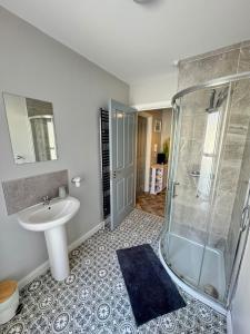a bathroom with a sink and a shower at Ogle Street 1-Bed Apartment in Armagh
