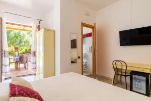 a bedroom with a bed and a view of a patio at Baja Azzurra in Bari Sardo