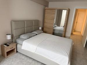 a bedroom with a large white bed and a mirror at Thomi's house. in Yerakiní +25 photos