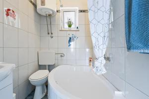 a bathroom with a toilet and a tub and a sink at Apartments Joy in Cavtat +142 photos