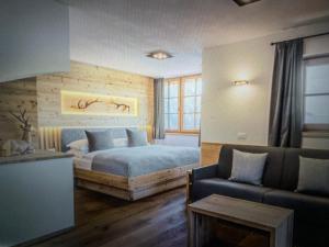 a bedroom with a bed and a couch at Casa Belluno in Belluno
