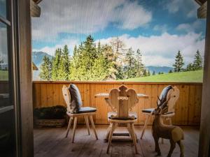 a patio with three chairs and a table and a mural at Casa Belluno in Belluno