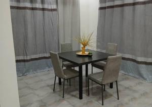 a black dining room table with chairs and a vase on it at Zahra Suites in Elephant Island