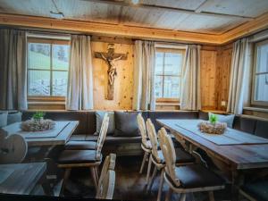 a dining room with two tables and a cross on the wall at Casa Belluno in Belluno