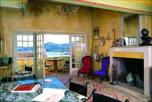 a living room with a fireplace and a table and chairs at Le Maria Venezia in LʼÎle-Rousse