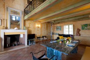 a living room with a table and a fireplace at Le Maria Venezia in LʼÎle-Rousse