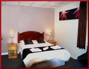 Hotel Vienna في بلاكبول: غرفة نوم عليها سرير ووسادتين