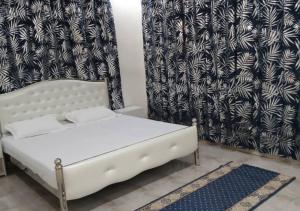 a white bed in a room with a curtain at Zahra Suites in Elephant Island
