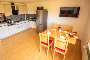a kitchen with a wooden table with chairs and a refrigerator at Hans-Girgl-Hof in Langdorf +70 photos