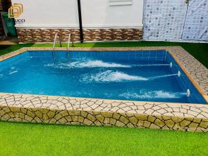a swimming pool with a wave in the water at Derucci Luxury Apartment in Owerri +3 photos