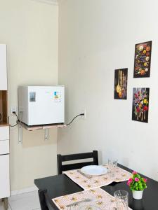 a kitchen with a table with a microwave on the wall at Casa do Graf 2 in Sorriso
