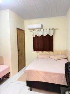a bedroom with a bed with a curtain above it at Casa do Graf 2 in Sorriso