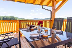 a table on a deck with a view of the mountains at Hans-Girgl-Hof in Langdorf