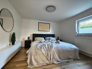 a bedroom with a large bed in a white room at Pfälzer Auszeit in Heuchelheim-Klingen