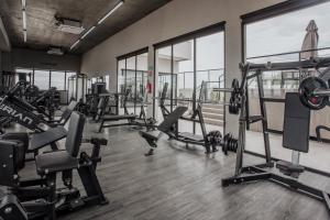 a gym with several tread machines and windows at Actual House in Uberlândia