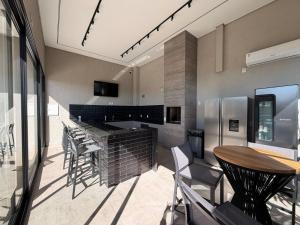 a kitchen with a bar and a table and chairs at Actual House in Uberlândia