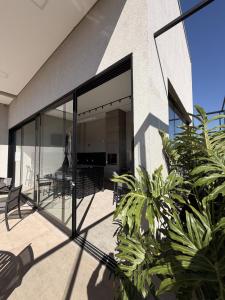 a glass extension of a house with plants at Actual House in Uberlândia