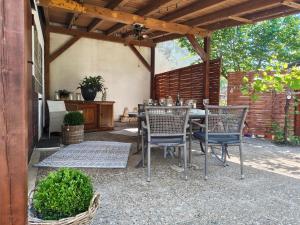 a patio with a table and chairs under a pergola at Pfälzer Auszeit in Heuchelheim-Klingen