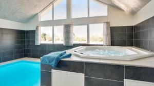 a large bathroom with a large tub and a large window at Villavilla 446 - Grenå Strand, Østjylland in Grenå