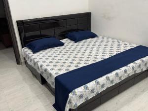 a bed with blue pillows in a bedroom at Bliss in Datia