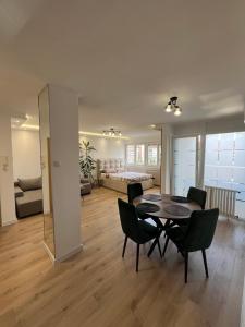 a living room with a table and chairs and a bedroom at Refresh apartman in Belgrade
